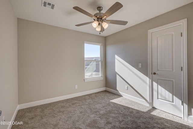 empty room featuring ceiling fan and light carpet