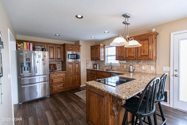 kitchen featuring stainless steel appliances, pendant lighting, dark hardwood / wood-style flooring, and decorative backsplash