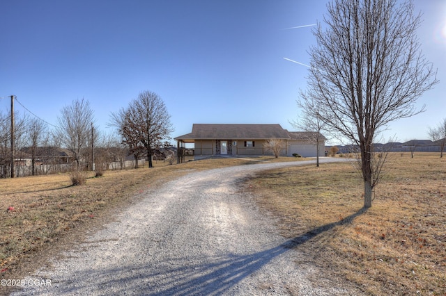 ranch-style home with a garage and a rural view