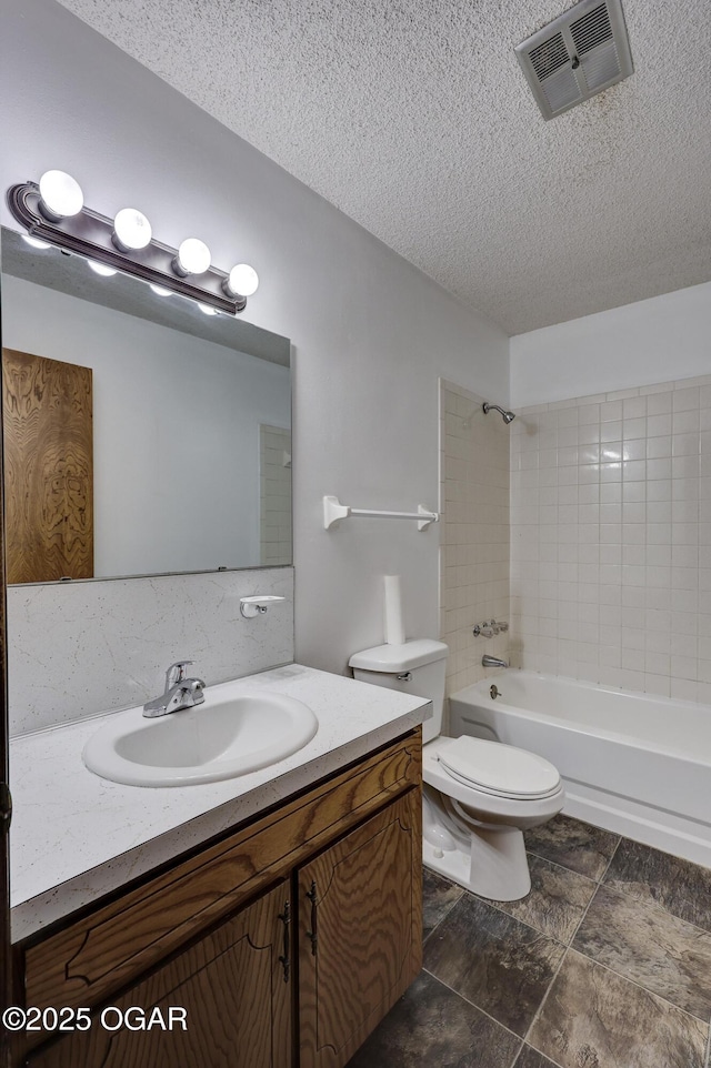 full bathroom with tiled shower / bath combo, vanity, a textured ceiling, and toilet