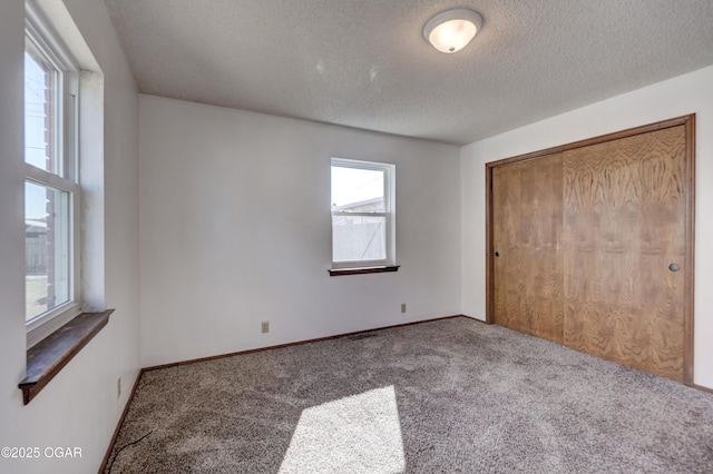 unfurnished bedroom with a closet, carpet, and a textured ceiling