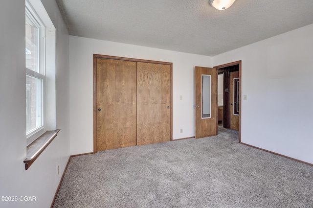 unfurnished bedroom with carpet, a textured ceiling, and a closet