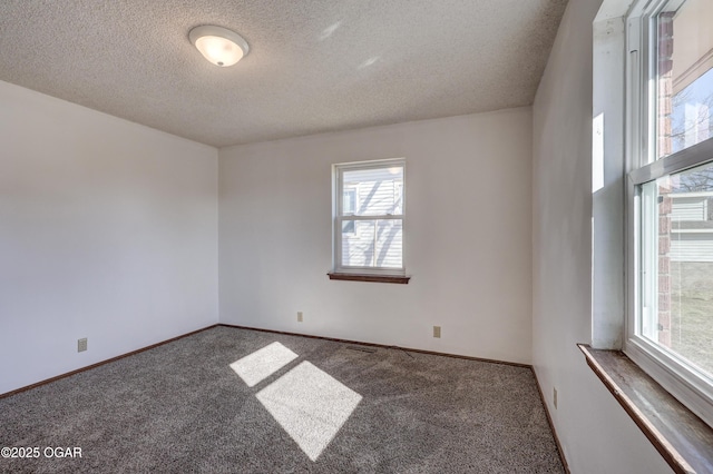 carpeted spare room with a textured ceiling