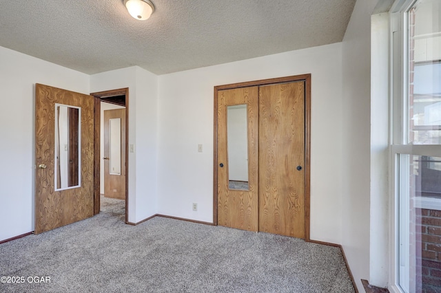 unfurnished bedroom featuring carpet flooring, a textured ceiling, and a closet