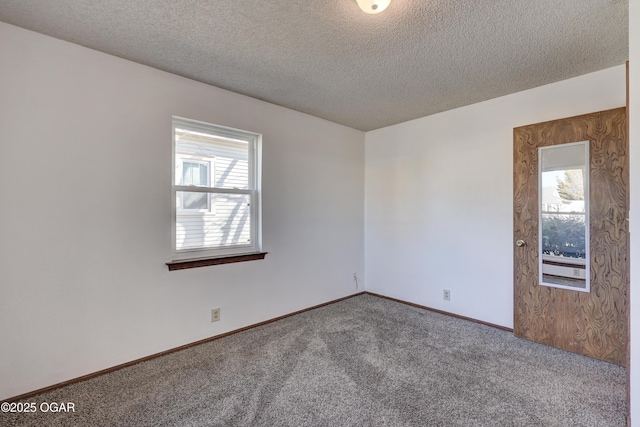 carpeted empty room with a textured ceiling