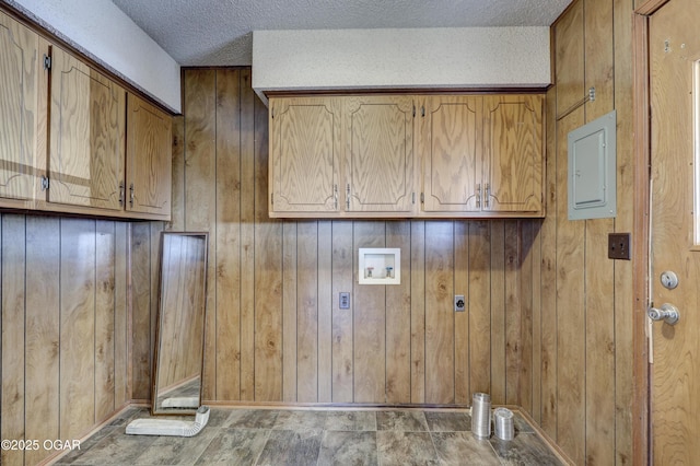 washroom with cabinets, washer hookup, electric panel, hookup for an electric dryer, and a textured ceiling