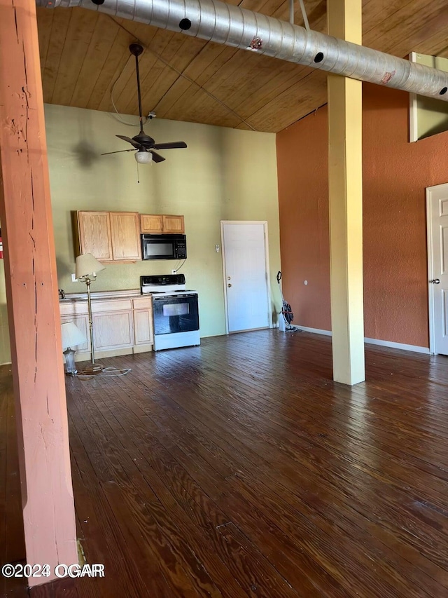 kitchen featuring range with electric stovetop, ceiling fan, a towering ceiling, and dark hardwood / wood-style flooring