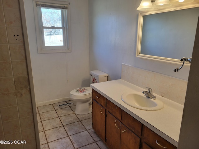 bathroom featuring tile patterned floors, vanity, toilet, and backsplash