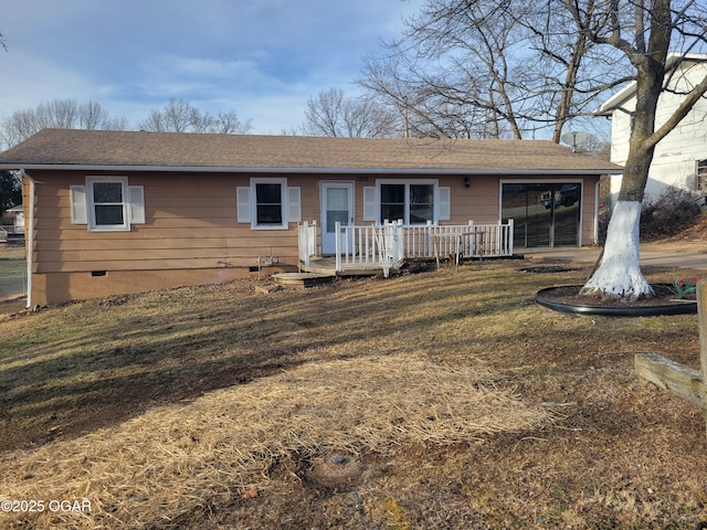 ranch-style house with a front yard and a deck