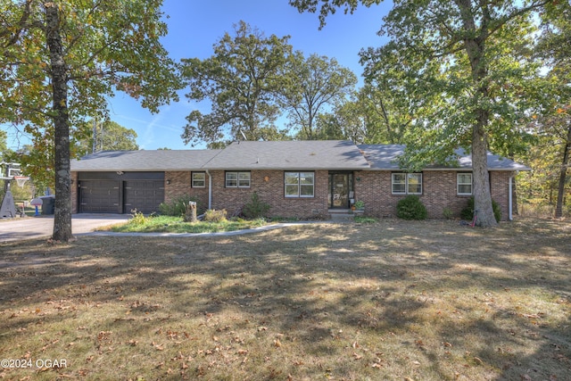 ranch-style home with a garage and a front lawn