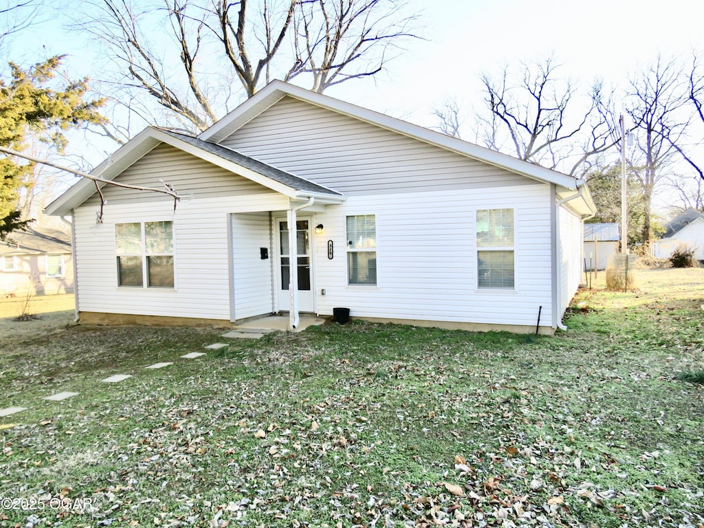 back of house featuring a lawn