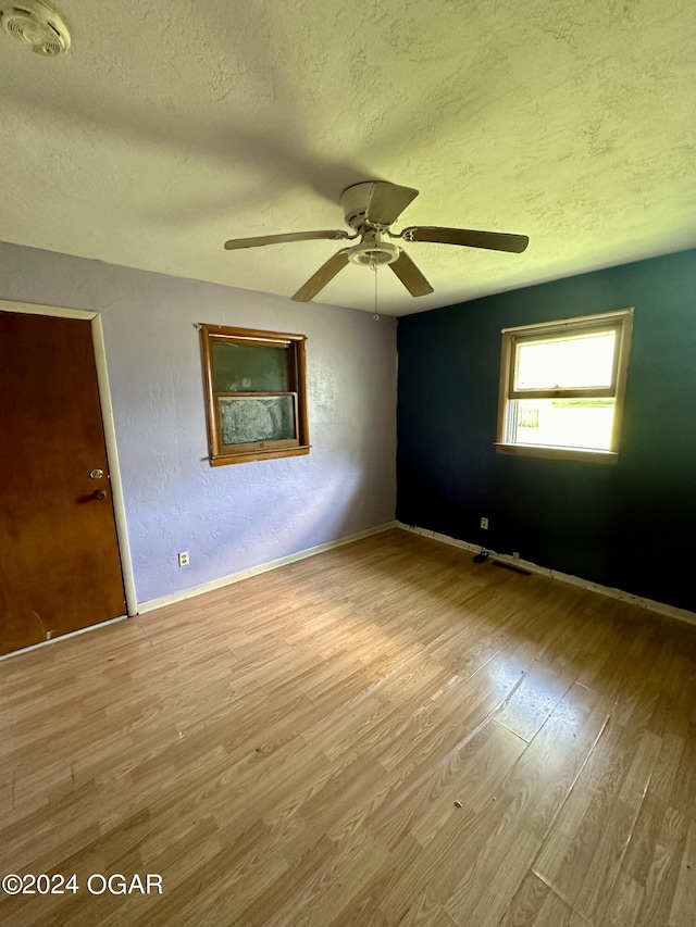 spare room featuring ceiling fan, a textured ceiling, and light wood-type flooring