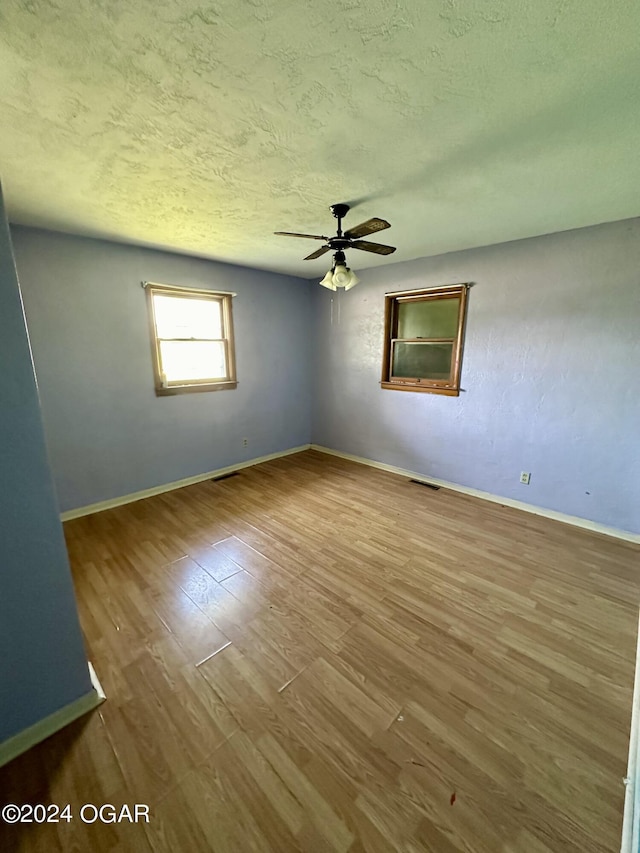 unfurnished room with hardwood / wood-style floors, a textured ceiling, and ceiling fan