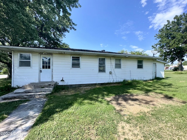 rear view of house featuring a lawn