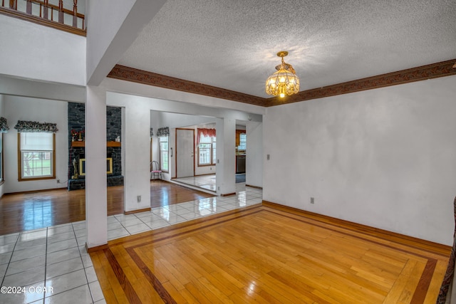 interior space featuring a chandelier, a fireplace, a textured ceiling, and light hardwood / wood-style flooring