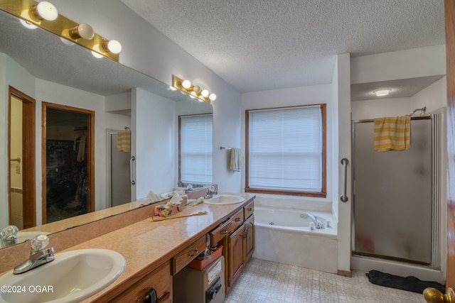 bathroom featuring vanity, separate shower and tub, and a textured ceiling