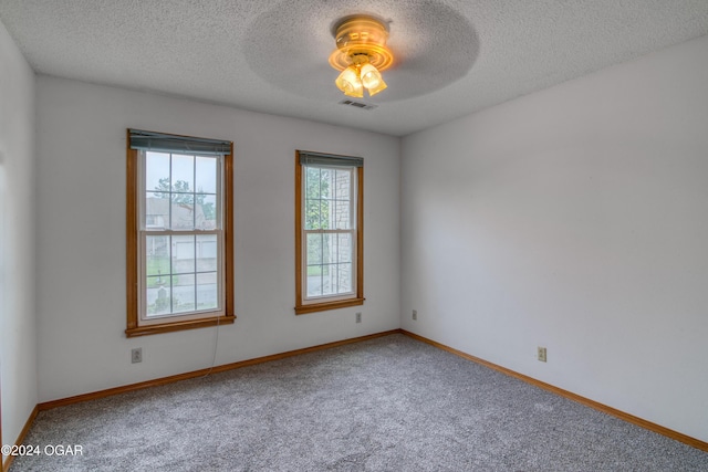 spare room with a textured ceiling, carpet floors, and ceiling fan