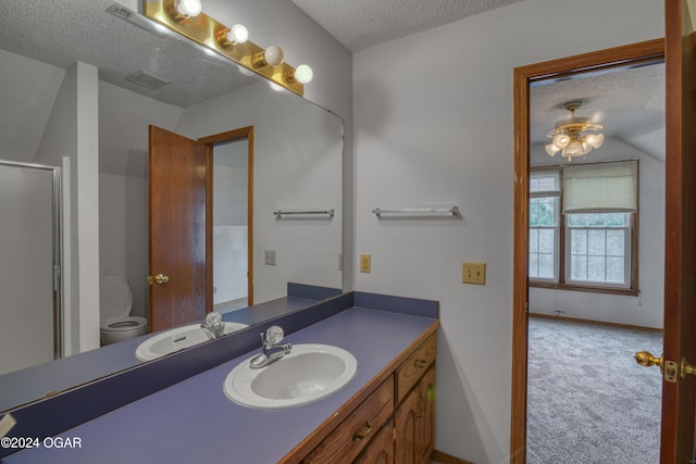 bathroom with vanity, an enclosed shower, a textured ceiling, and toilet