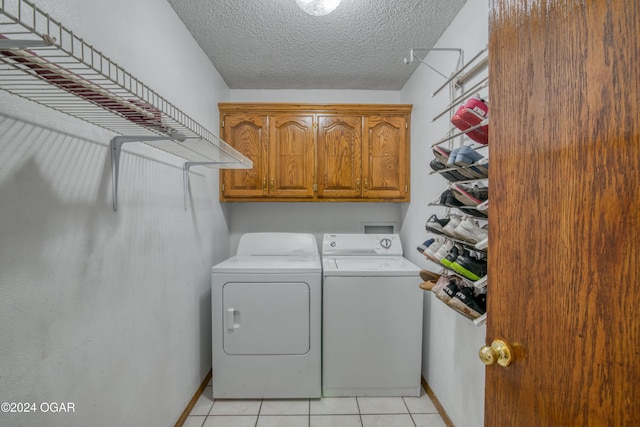 washroom featuring cabinets, separate washer and dryer, a textured ceiling, and light tile patterned floors