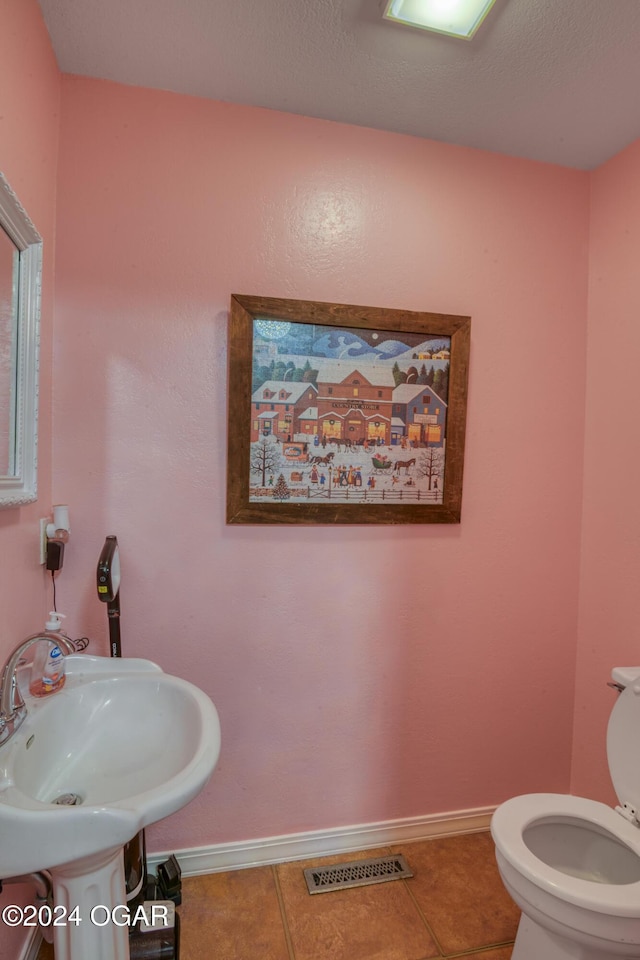 bathroom featuring sink, tile patterned floors, and toilet