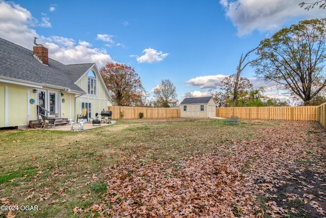 view of yard with a storage shed and a patio area