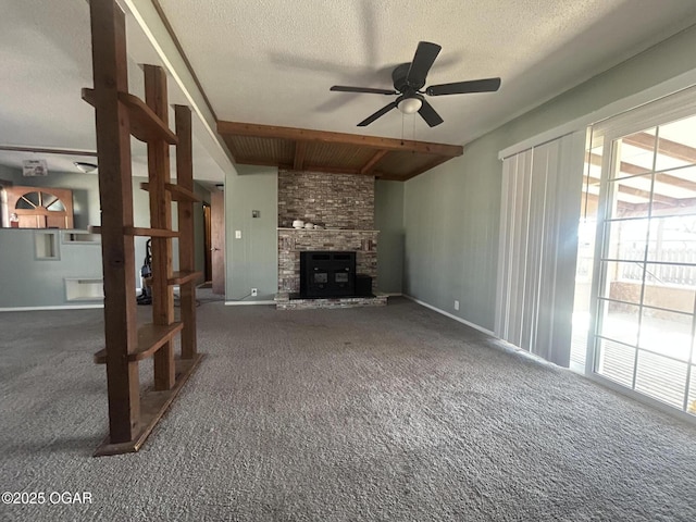 unfurnished living room featuring beamed ceiling, carpet flooring, plenty of natural light, and a fireplace