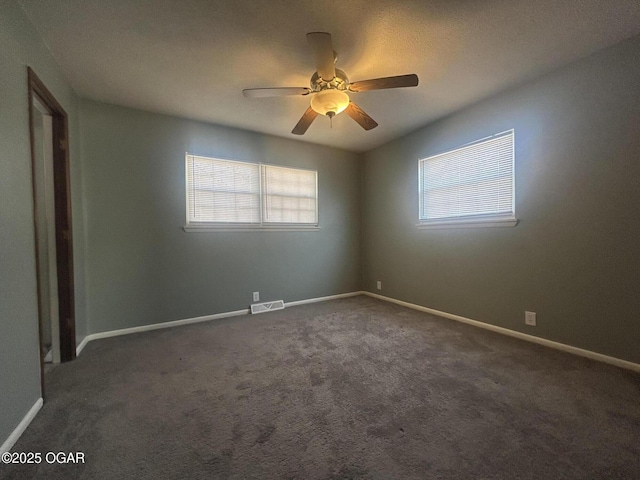 unfurnished room featuring ceiling fan and dark colored carpet