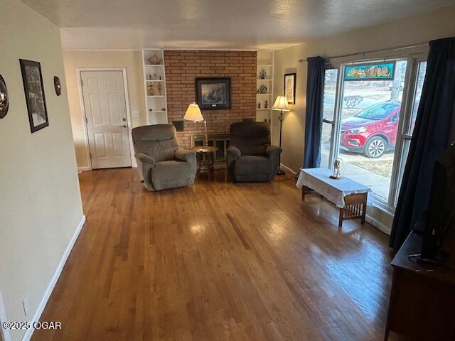 living room featuring hardwood / wood-style flooring and built in shelves