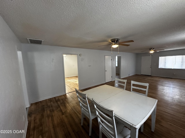 unfurnished dining area with dark wood-type flooring and a textured ceiling