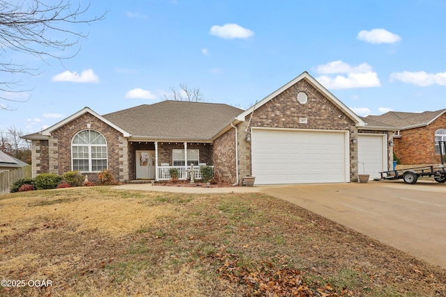 ranch-style house featuring a garage, covered porch, and a front yard