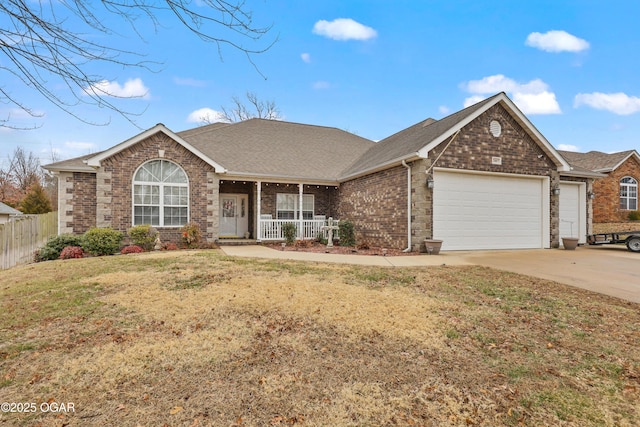 ranch-style home featuring a garage, covered porch, and a front yard