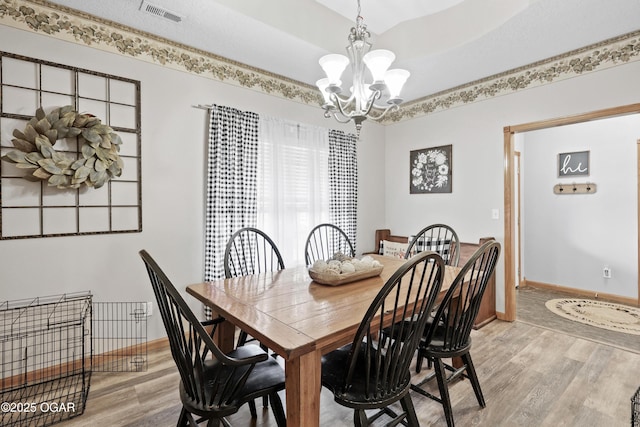 dining area featuring a chandelier and light wood-type flooring