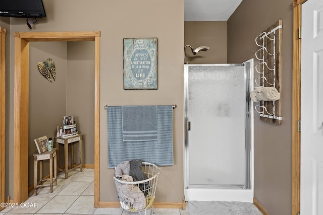 bathroom with an enclosed shower and tile patterned flooring