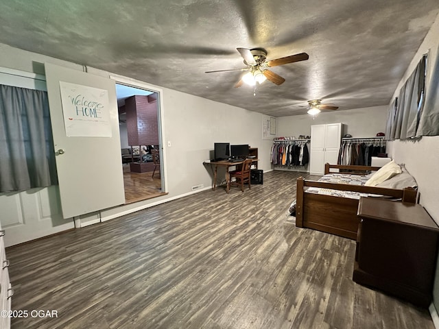 interior space with a textured ceiling, dark hardwood / wood-style floors, and ceiling fan