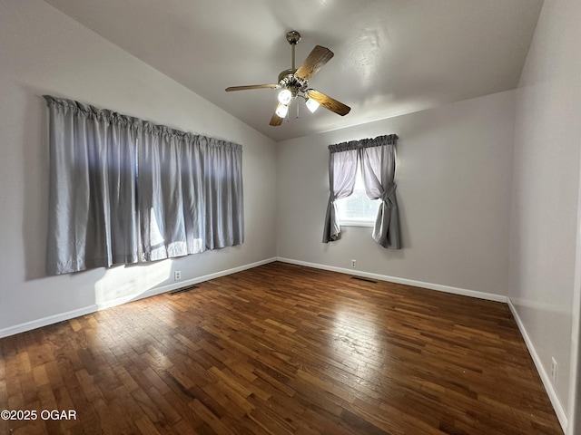 spare room featuring dark wood-type flooring, ceiling fan, and vaulted ceiling