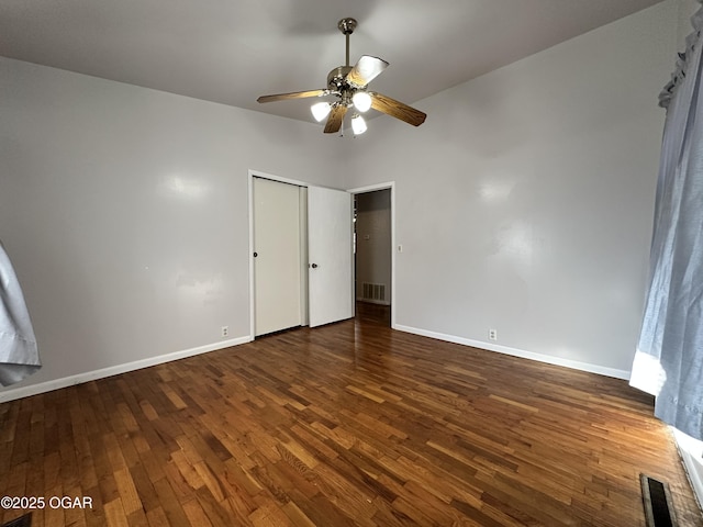 unfurnished bedroom with dark hardwood / wood-style flooring, a closet, and ceiling fan