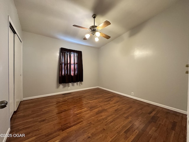 unfurnished bedroom with ceiling fan, dark hardwood / wood-style flooring, and a closet