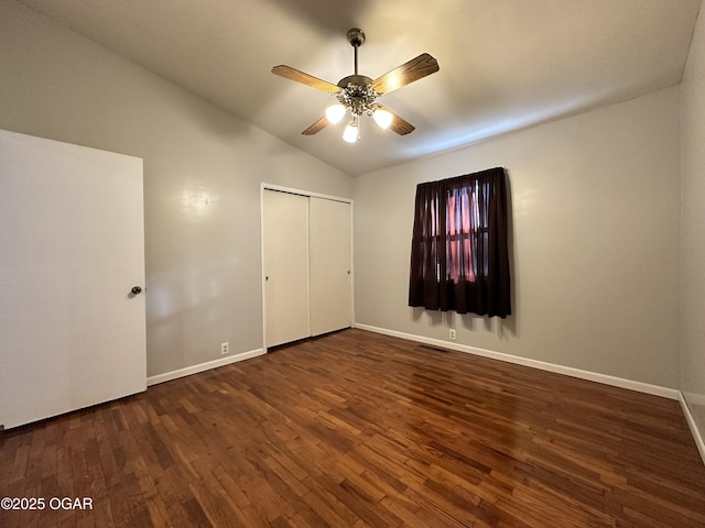 unfurnished bedroom with vaulted ceiling, ceiling fan, dark hardwood / wood-style flooring, and a closet