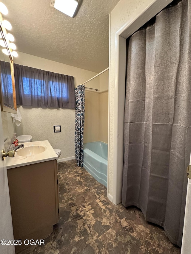 full bathroom featuring vanity, shower / tub combo, toilet, and a textured ceiling