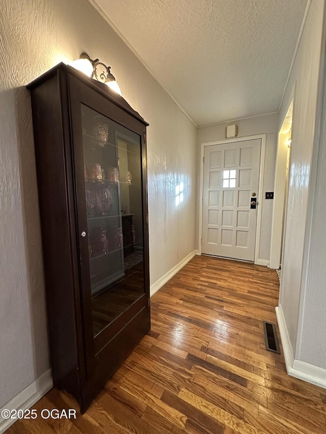 entryway with hardwood / wood-style flooring and a textured ceiling