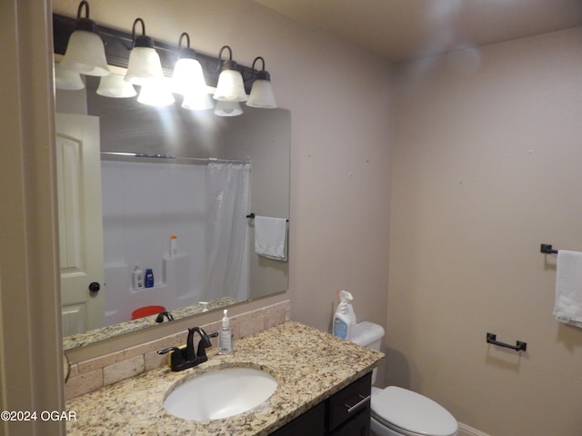 bathroom with walk in shower, vanity, and toilet