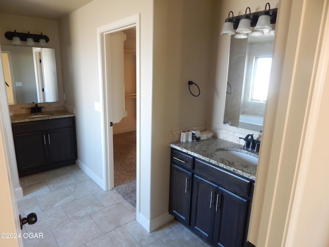 bathroom featuring vanity, tile patterned floors, and a tub