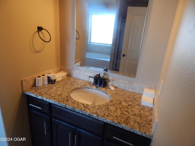 bathroom featuring vanity and a bath