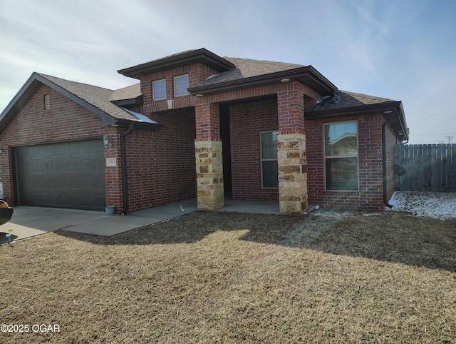 view of front of house featuring a garage, brick siding, a front lawn, and roof with shingles