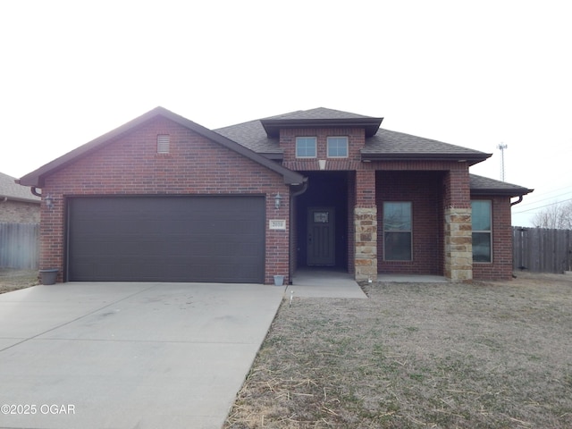 view of front of house with an attached garage, a shingled roof, fence, concrete driveway, and a front lawn