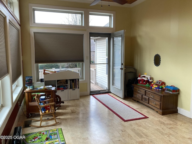 doorway with crown molding, ceiling fan, and a healthy amount of sunlight