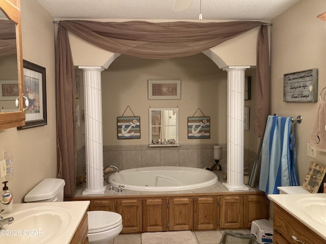 bathroom featuring vanity, a tub, toilet, and ornate columns