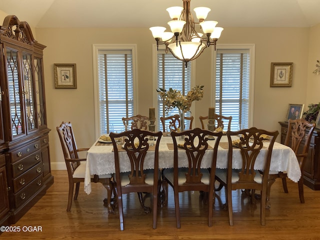 dining space featuring hardwood / wood-style floors, a wealth of natural light, and a chandelier