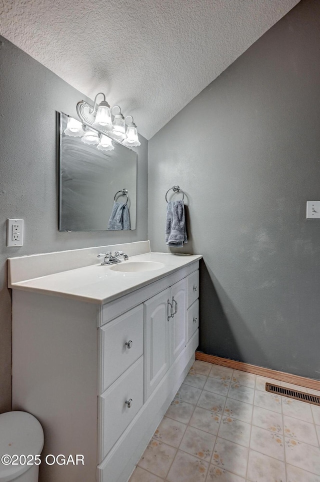 bathroom featuring vanity, an inviting chandelier, and a textured ceiling