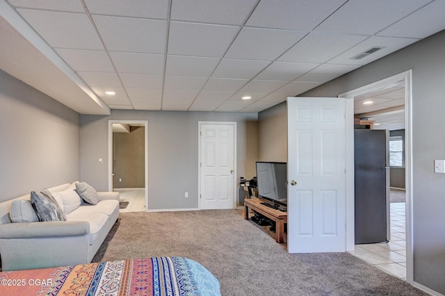 living room with a paneled ceiling and light carpet